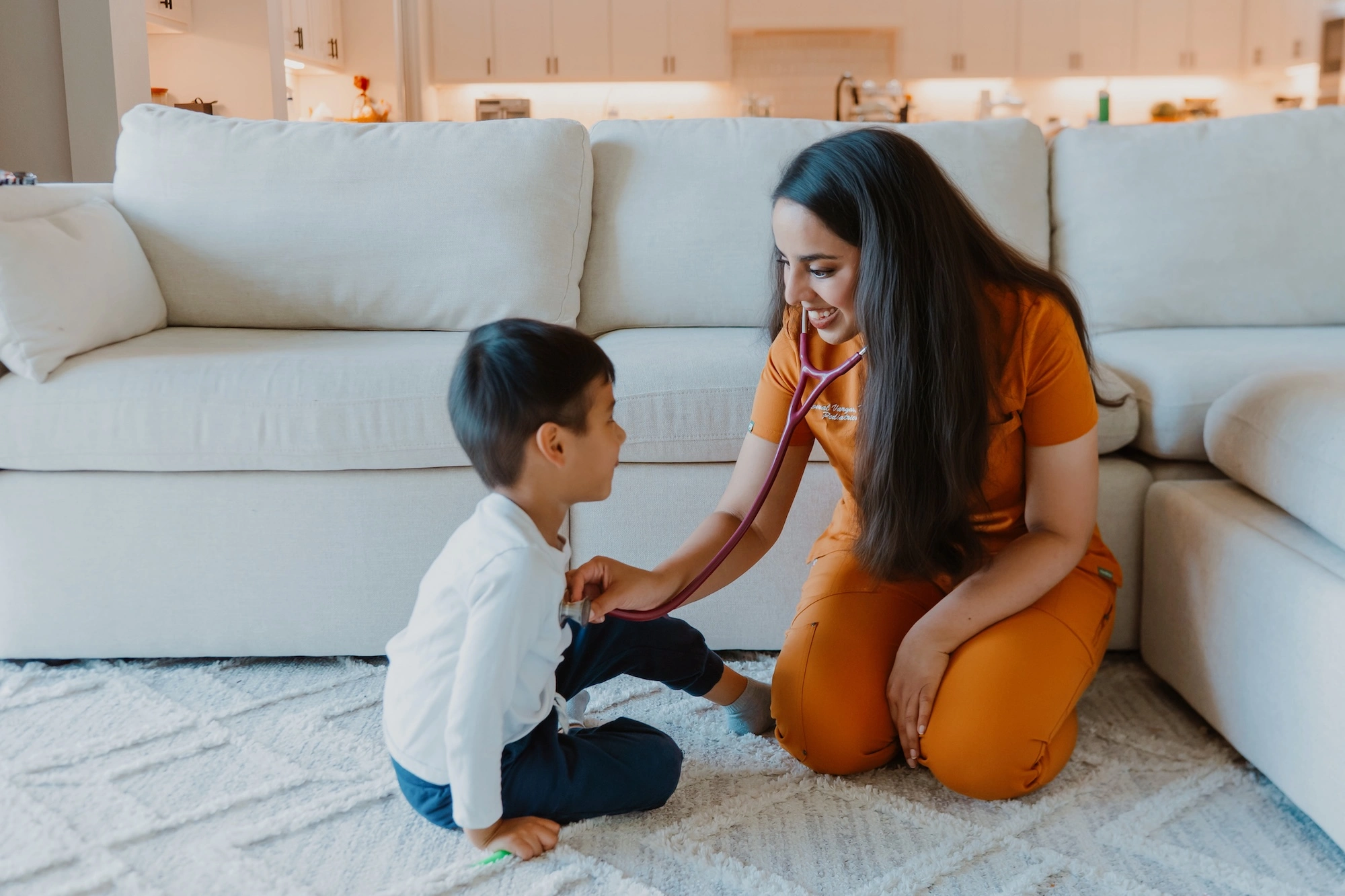 Dr. Komal Vargas, founder of Marigold Pediatrics, checks a child's heartbeat with a stethoscope.